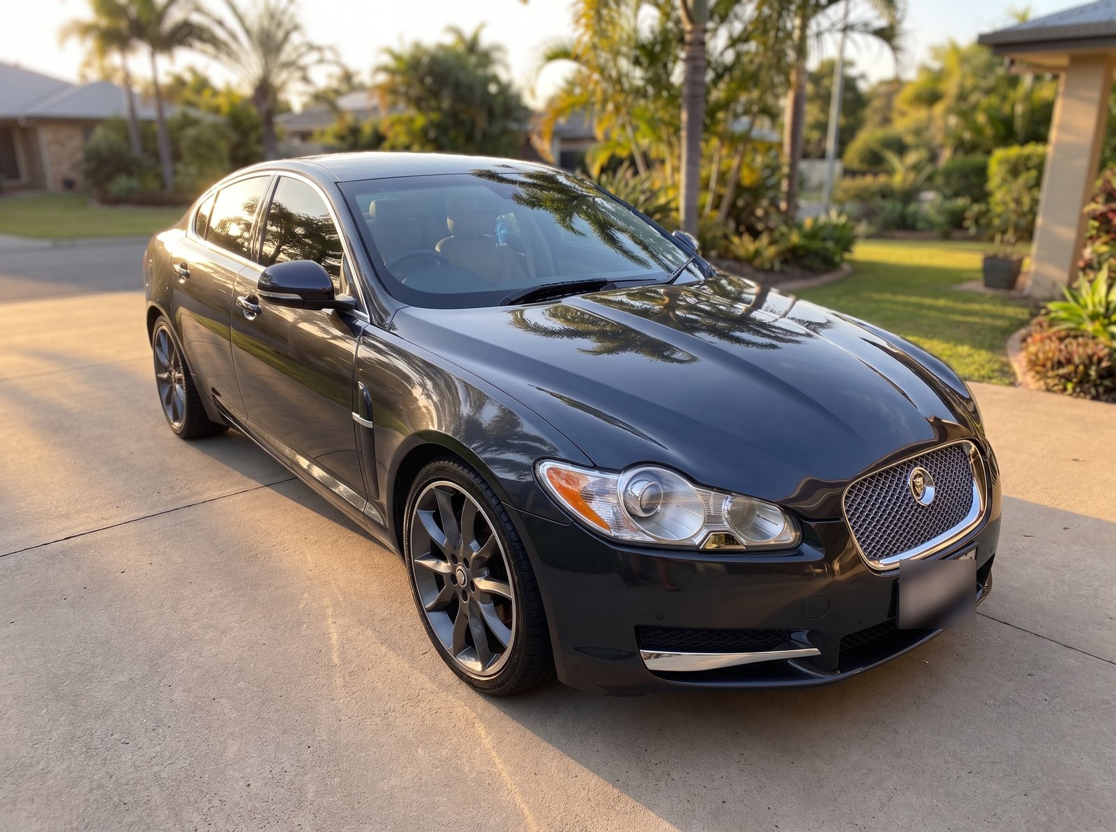 Dark grey Jaguar XF, freshly detailed, front three-quarter view